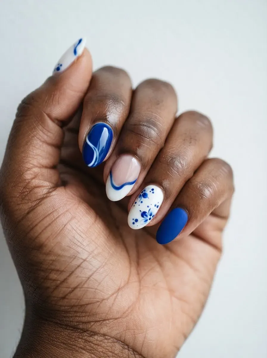 Close-up of nails in blue and white mixed set on rich dark skin tone