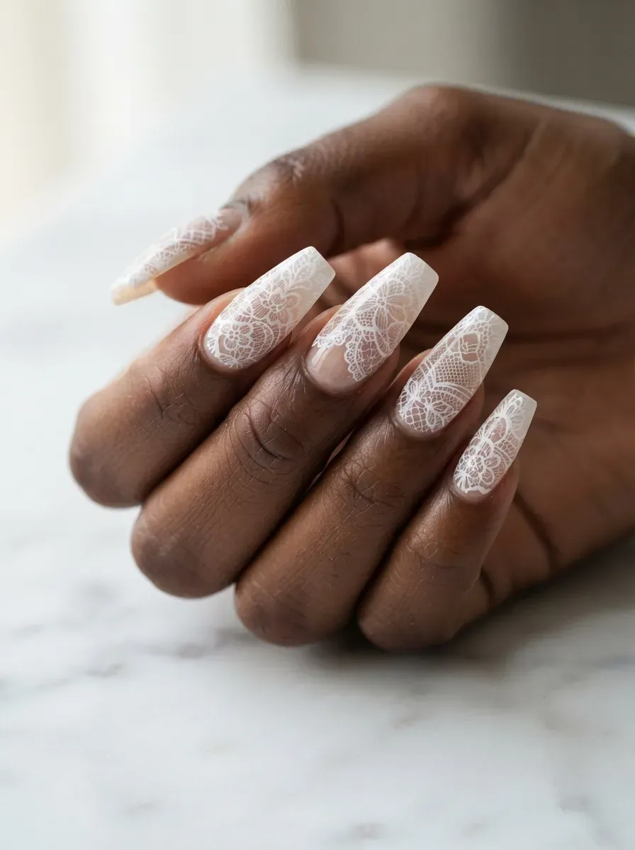 Close-up of long coffin nails with full white lace on deep brown skin