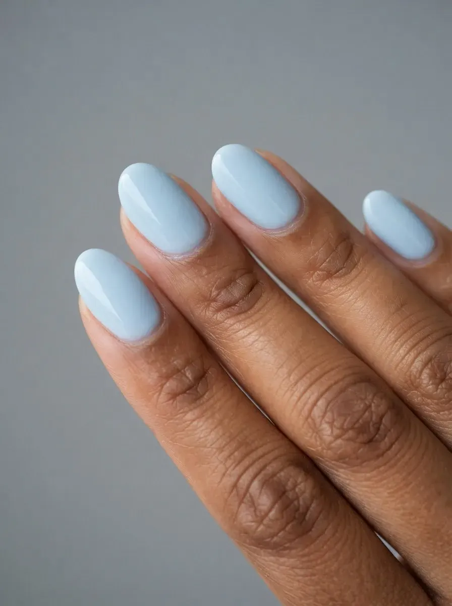 Close-up of oval nails in glacier blue on warm brown skin