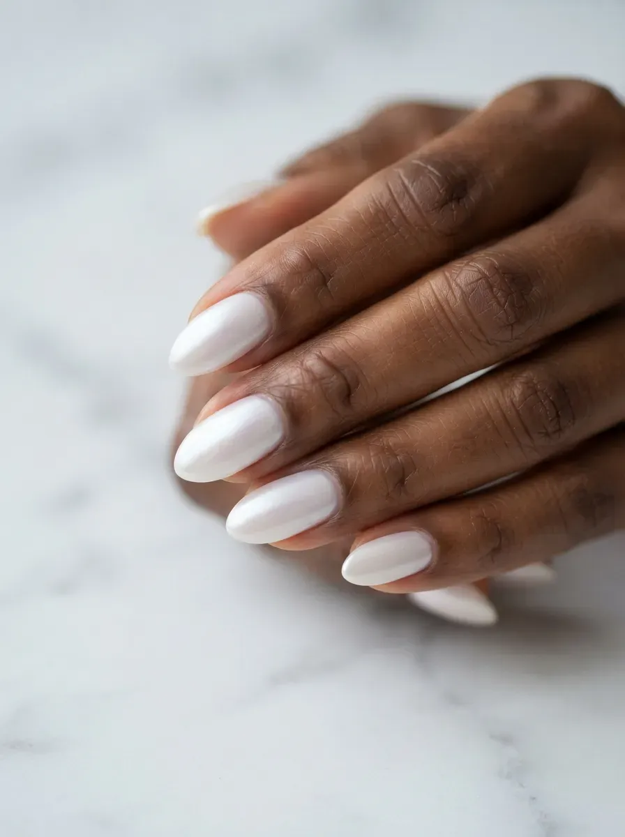 Close up of almond nails with milky white polish and soft pearlescent chrome sheen