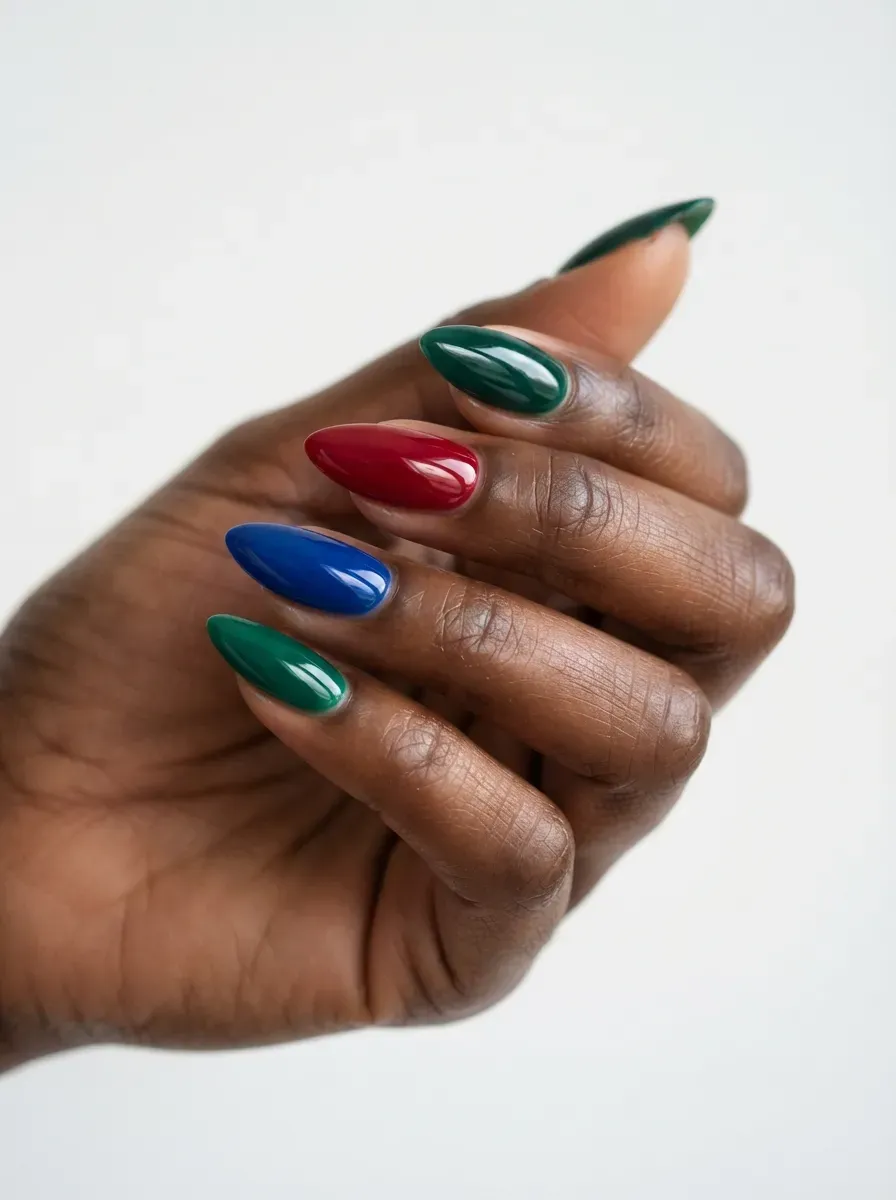 Close-up of almond nails in emerald ruby sapphire jewel tones
