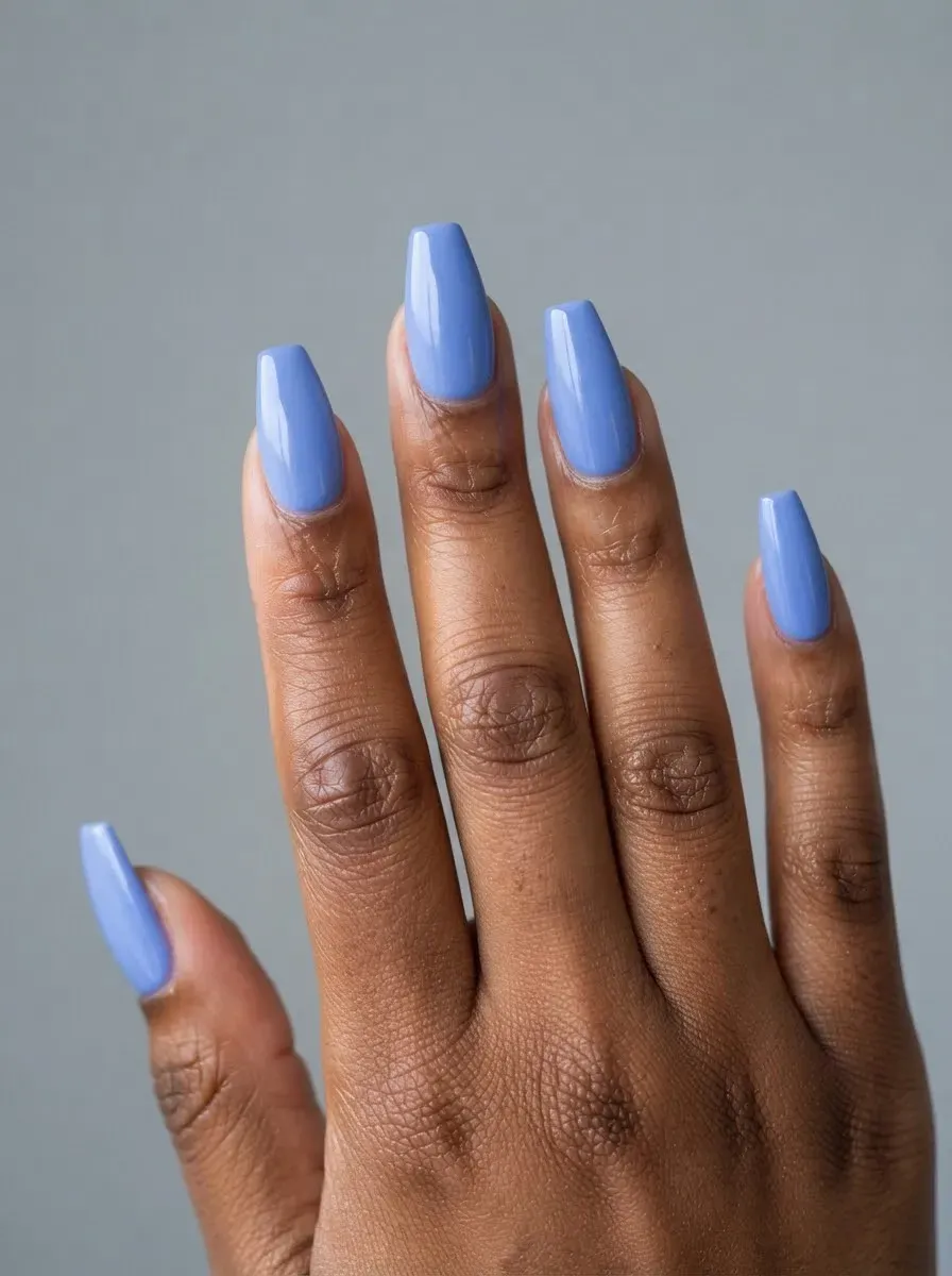 Close-up of coffin nails in periwinkle blue on brown skin and warm undertones
