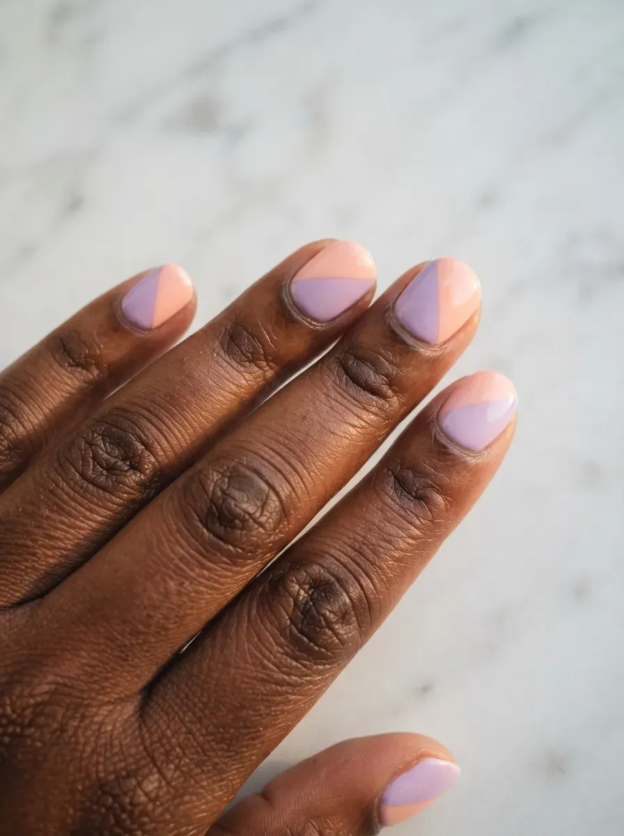 Close-up of round nails with soft pastel color block sections