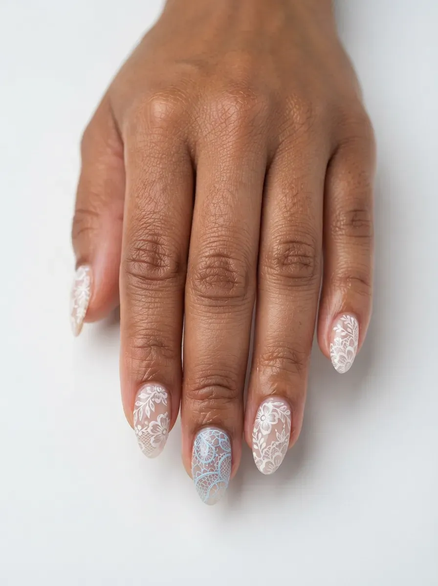 Close-up of almond nails with lace and pale blue lace accent nail on brown skin